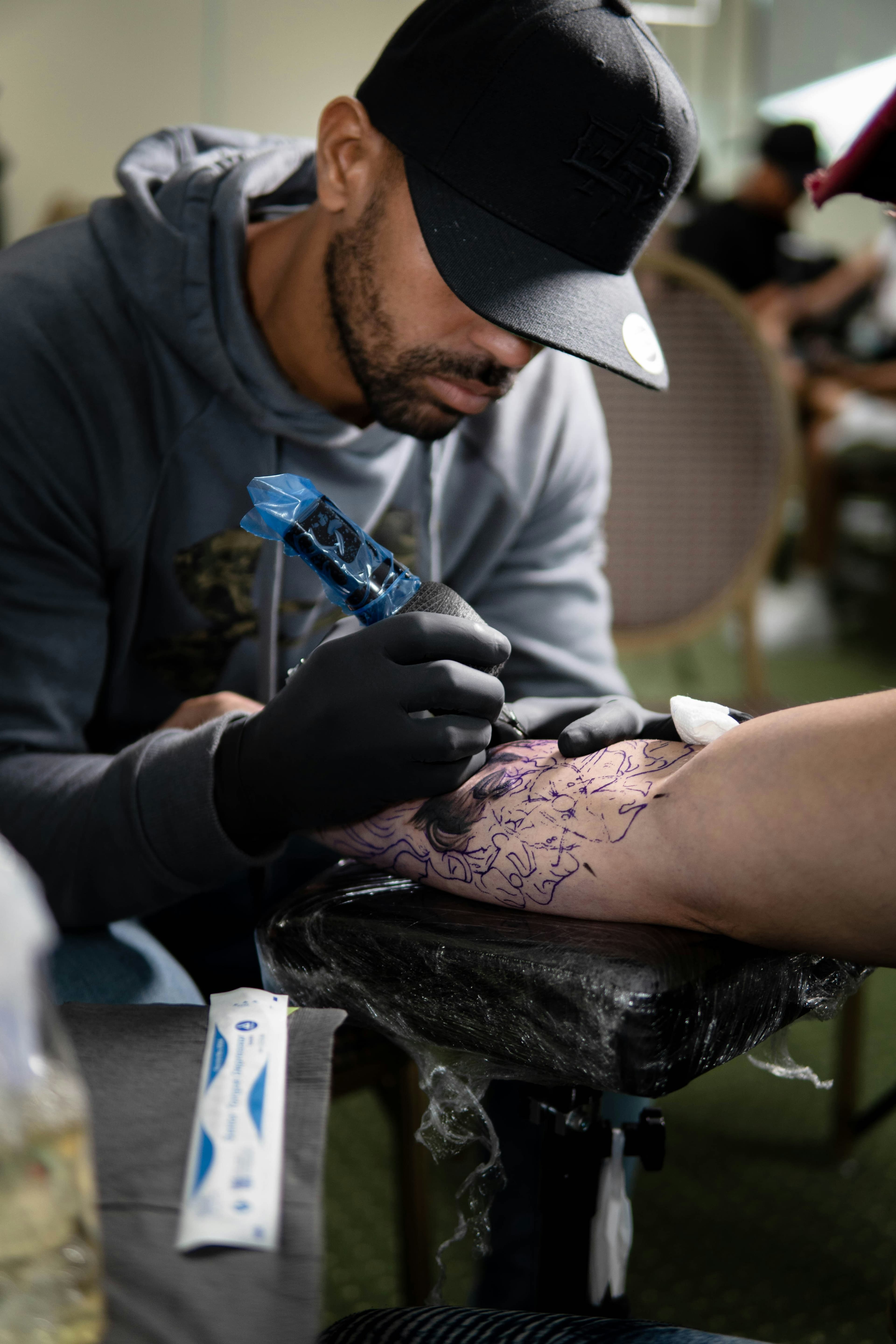 Tattoo artist carefully inking a detailed design on a client's arm